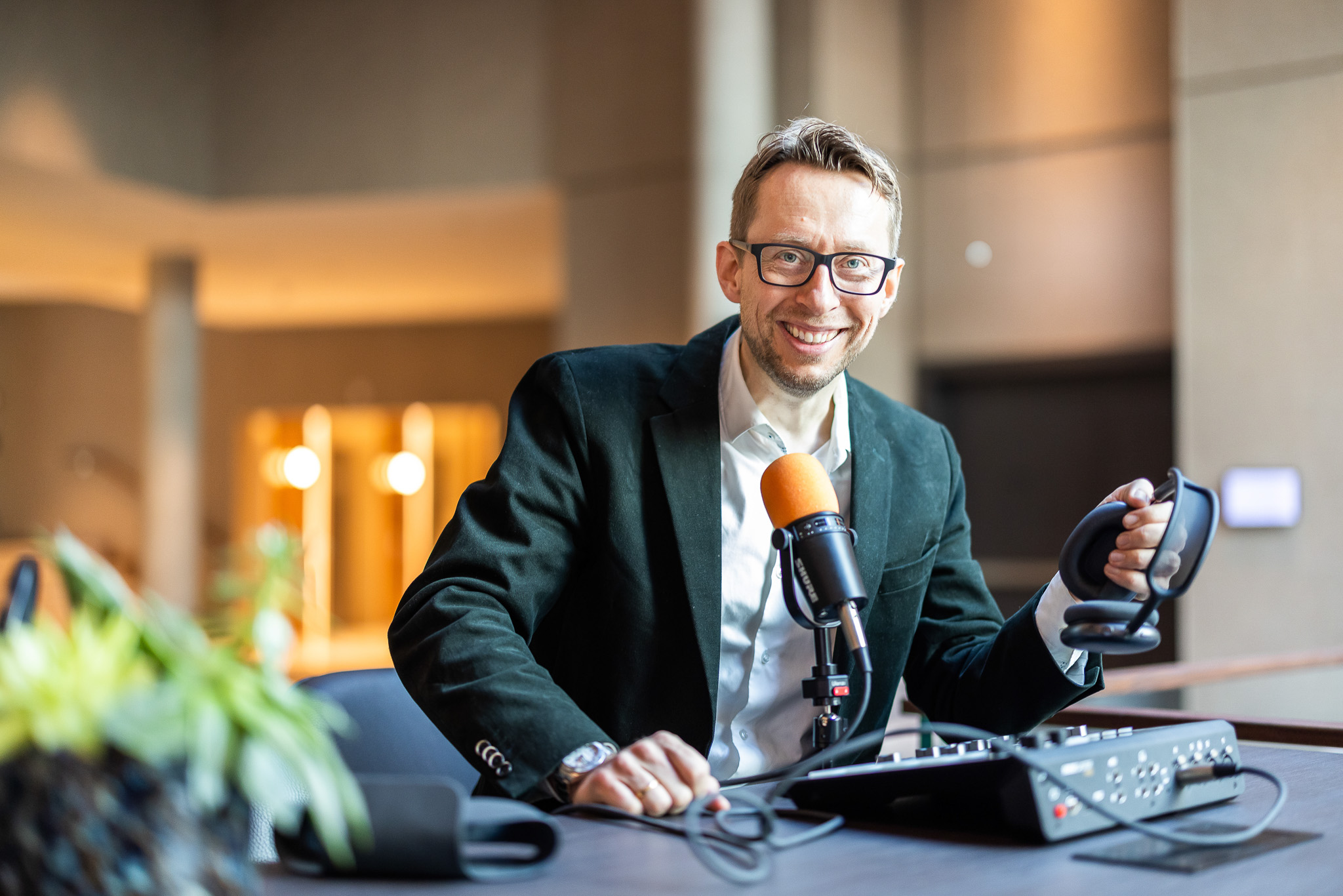 Daniel Schwenger at a recording desk with microphone, mixer and headphones