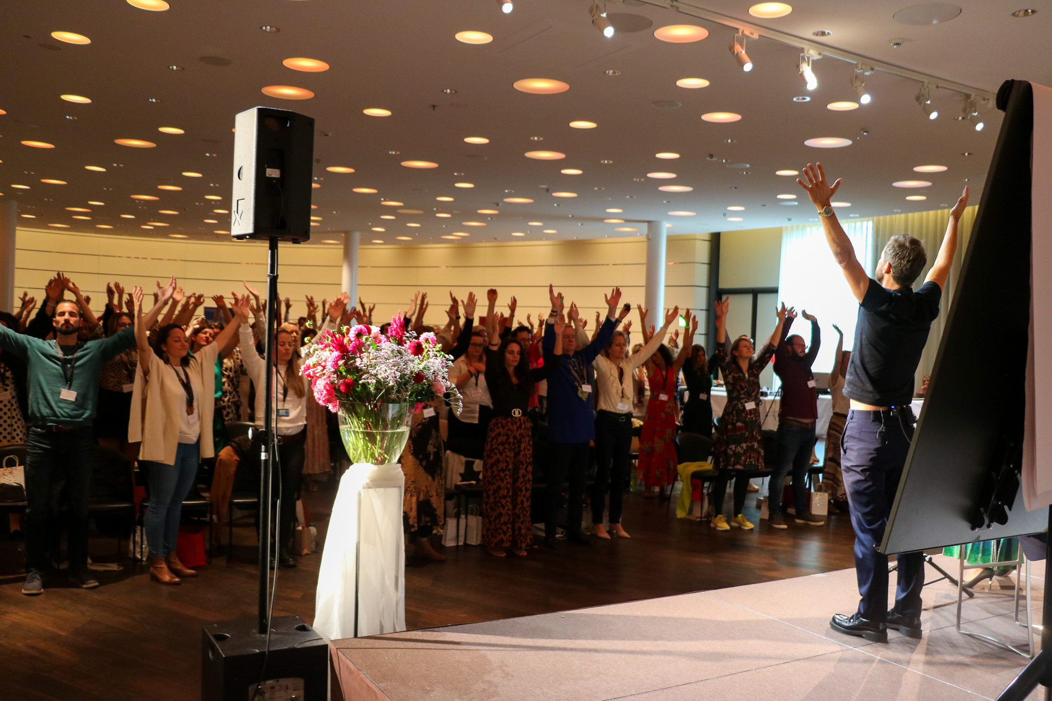 Audience raising their arms with the speaker