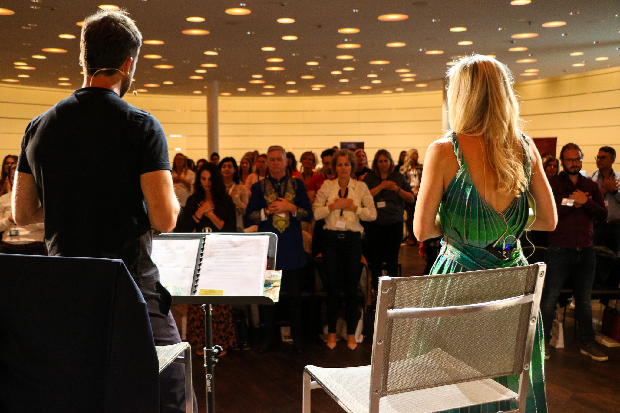 Two speakers facing a standing audience